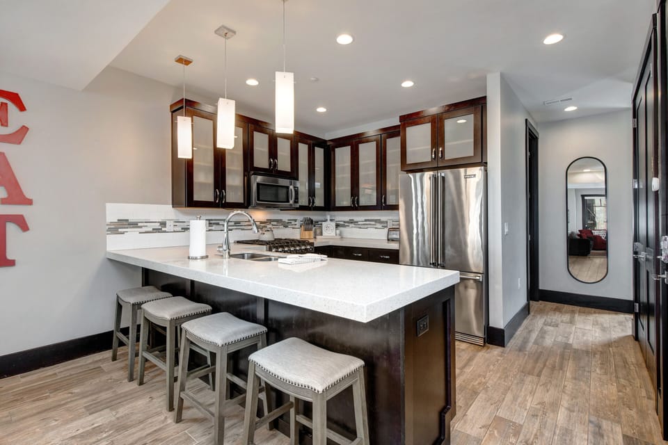 Fully Equipped kitchen with gorgeous stone countertops, stainless steel Viking appliances, and bar seating for four