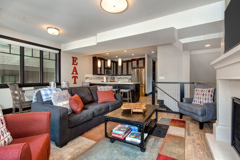 Living Room with 55" Samsung smart tv, plush furniture with sleeper-sofa, gas fireplace, and small work area