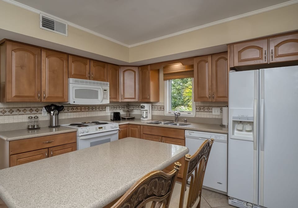 The kitchen is the perfect spot to create some delicious family meals. A breakfast bar with two bar stools.