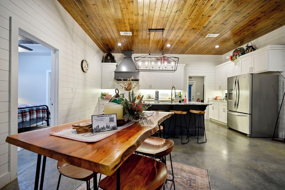 Step into your open-concept kitchen with stunning wood ceilings, modern appliances, and a cozy dining nook perfect for morning coffee.