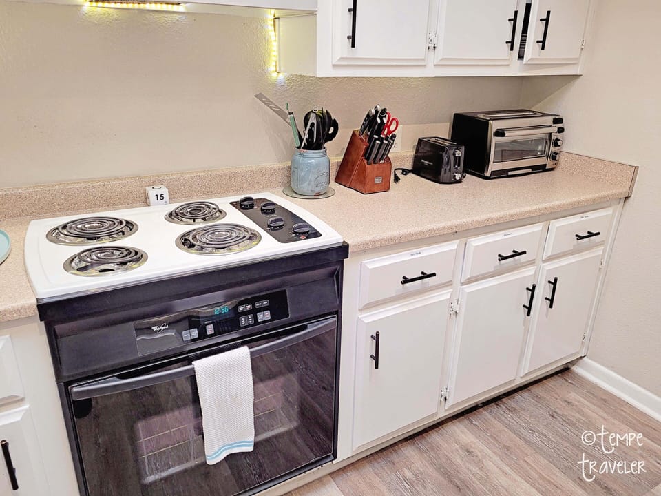 The kitchen has a stove/oven, toaster oven, toaster, and microwave.