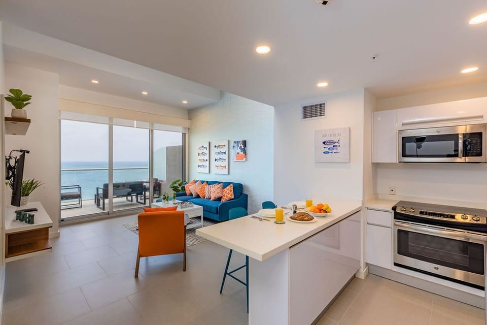 Your bright, modern space flows effortlessly from kitchen to living area, with stunning ocean views greeting you through floor-to-ceiling windows and a private balcony just steps away.
