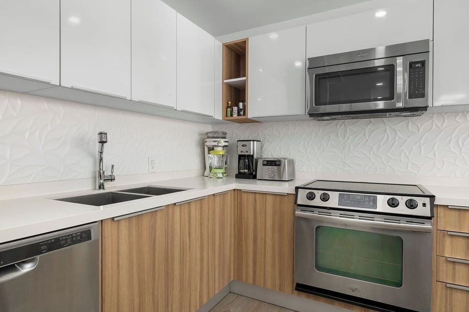 Your modern kitchen features sleek white countertops, stainless steel appliances, and everything you need to create memorable meals during your stay.