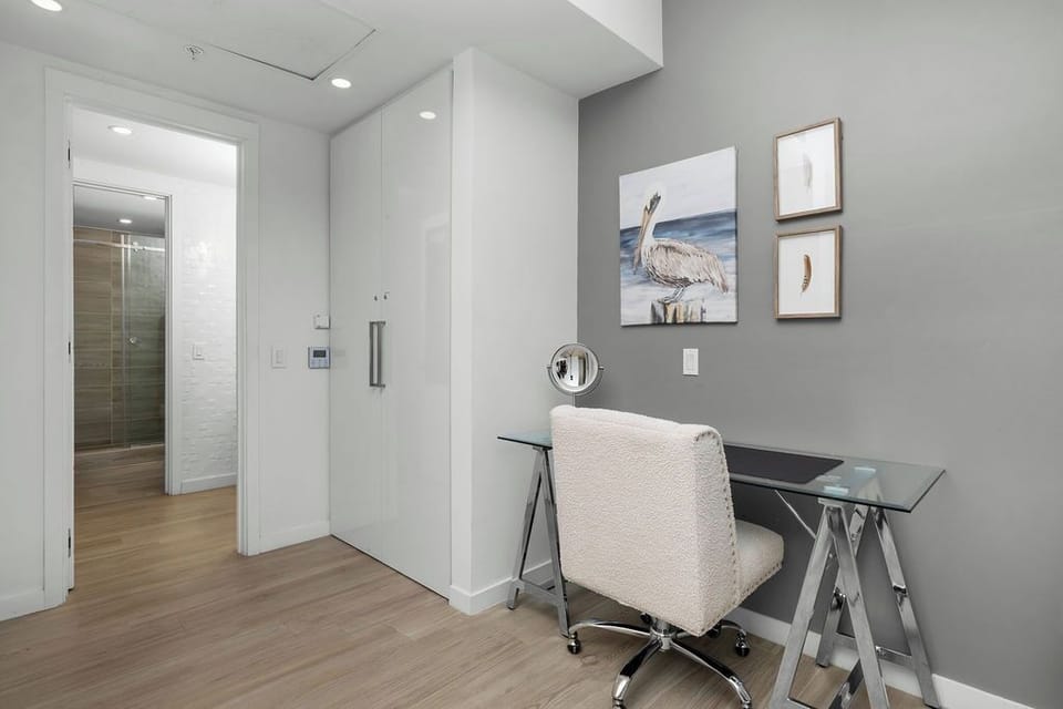 Your private workspace awaits with a sleek glass desk and ergonomic chair, perfectly positioned for productivity in this modern space.