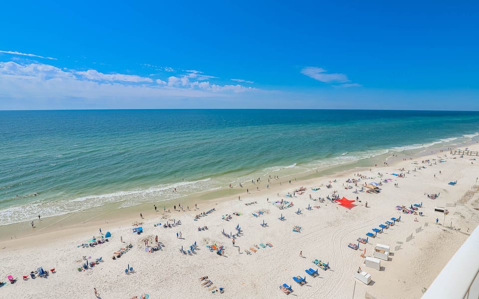 Enjoy the vibrant beach scene with colorful chairs and umbrellas, perfect for sunbathing and relaxation