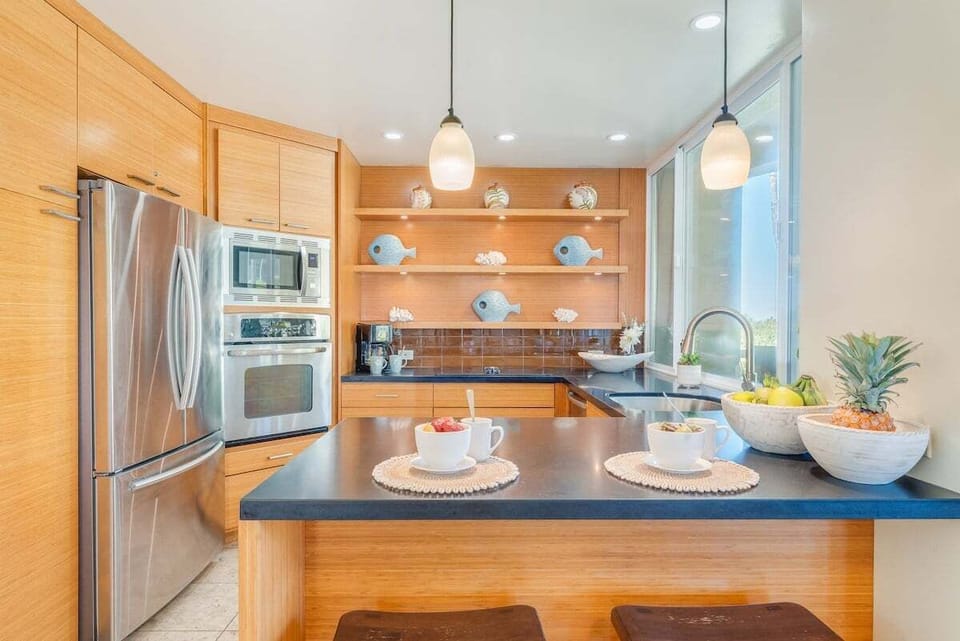 Cook with ease in a modern kitchen featuring stainless steel appliances, open shelving, and a welcoming island.