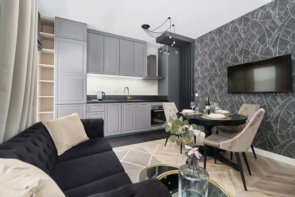 A different angle showing the open-plan design that connects the living and dining areas. A patterned wallpaper accentuates the wall.