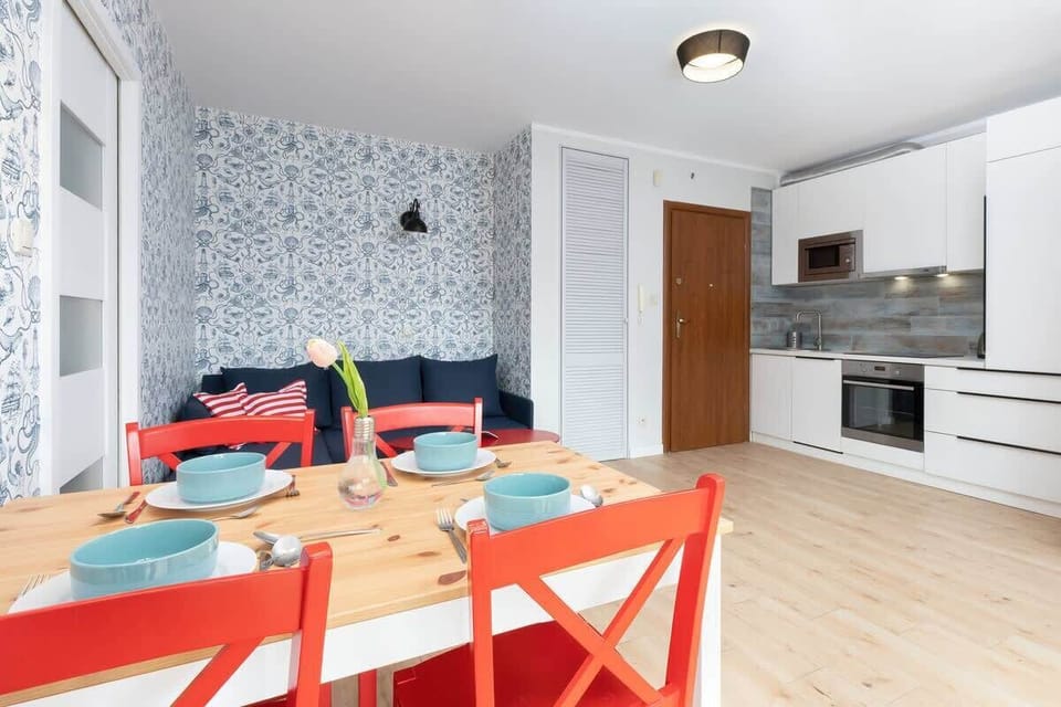 Dining area with wooden table and red chairs that add a special touch.