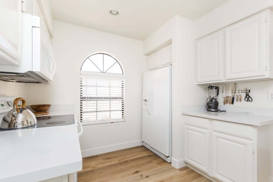 The fully equipped modern kitchen is stocked with all culinary essentials and breakfast bar seating.