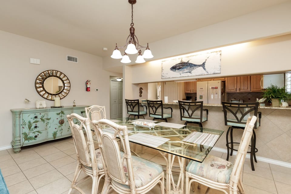 Gather around your elegant glass dining table where coastal charm meets comfort, perfect for memorable meals with family and friends.