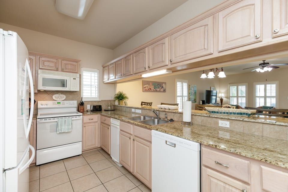 Cook memorable meals in your spacious kitchen with granite countertops, white appliances, and open bar perfect for morning coffee.