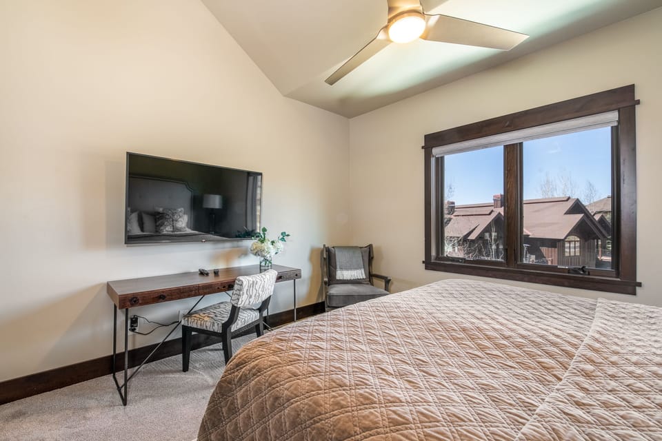 Upper guest room with large screen tv and desk