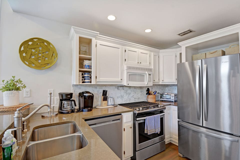 Kitchen Sink and Appliance Wall - Second kitchen angle shows the deep sink, dishwasher, range, refrigerator, and coffee setup.