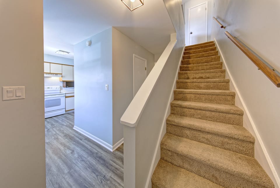 Hallway connecting kitchen and living area to upstairs. Downstairs bathroom.