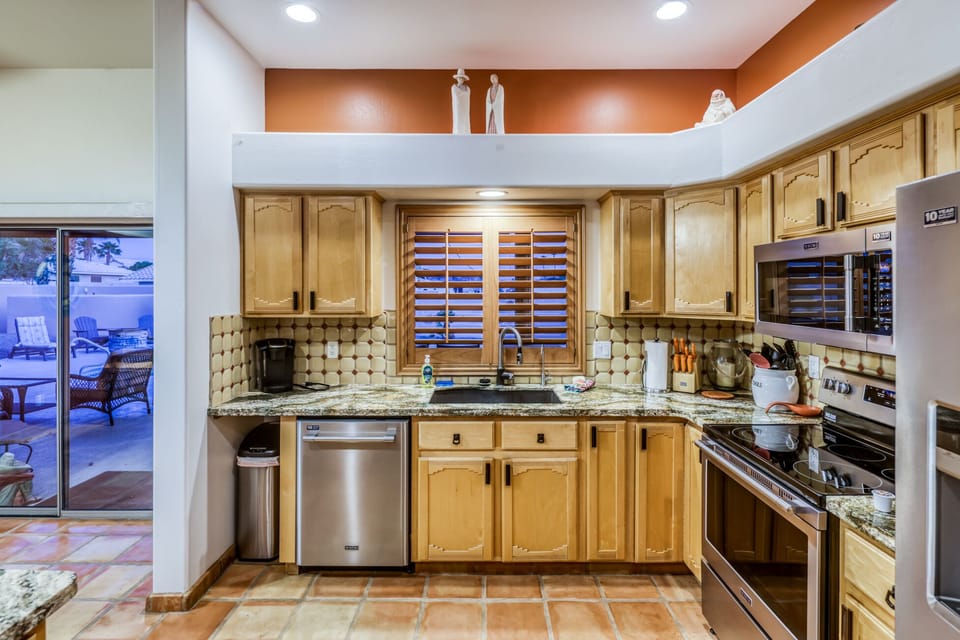 Kitchen’s main sink area with view to pool & patio, and quick access!