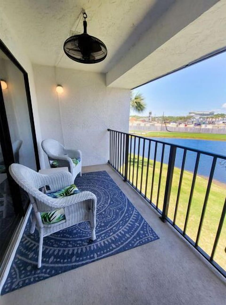Balcony with fan overlooking pond and third hole of golf course, access from living room and main bedroom