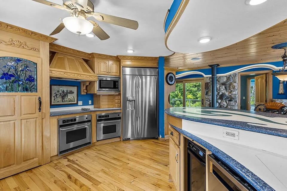 Bright chef’s kitchen with breakfast bar, dining space, and modern appliances