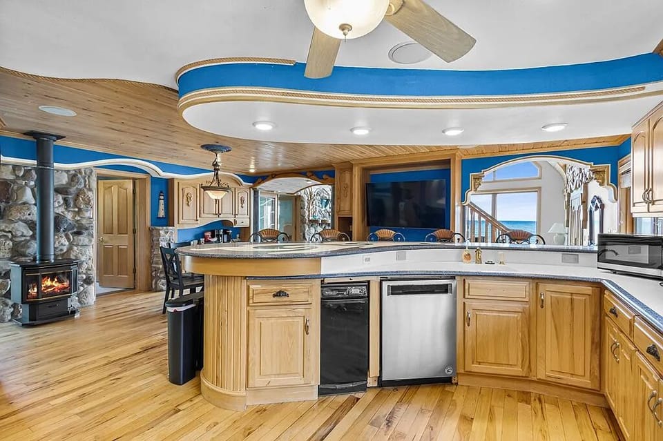 Chef-style commercial kitchen with double ovens, oversized fridge, and seating, built for large group meals and entertaining.