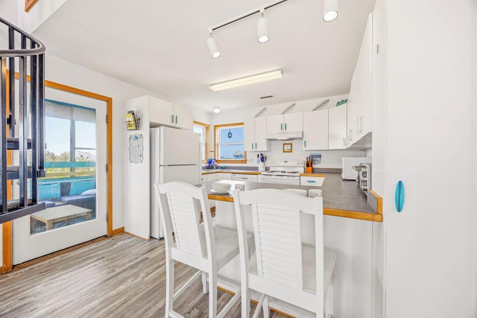 Picture yourself preparing meals in this bright, fully equipped kitchen with cheerful accents and natural light streaming through ocean-view windows—your perfect home base for beach getaways.