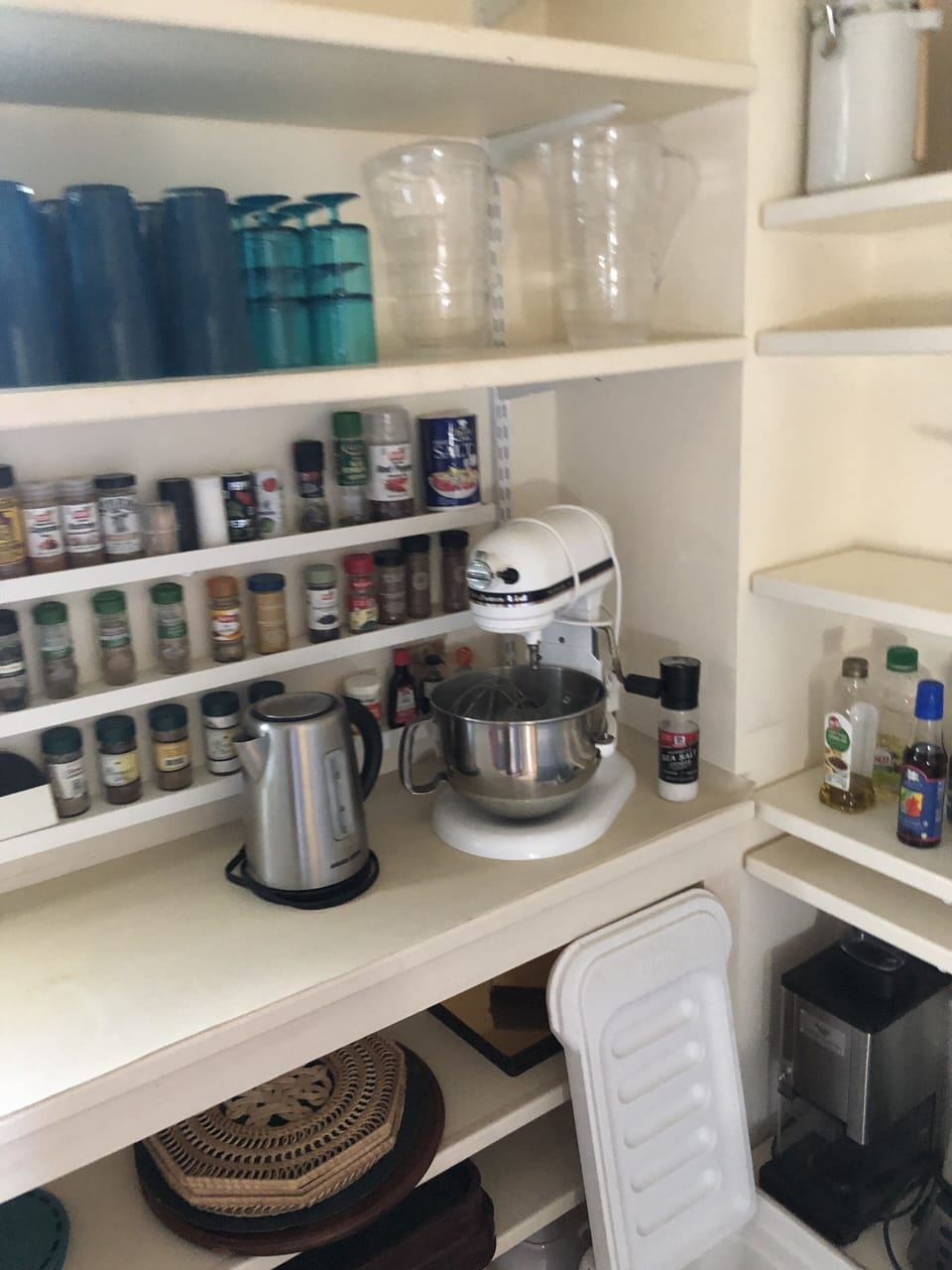 Kitchen pantry stocked with spices, oils, teas, vinegars