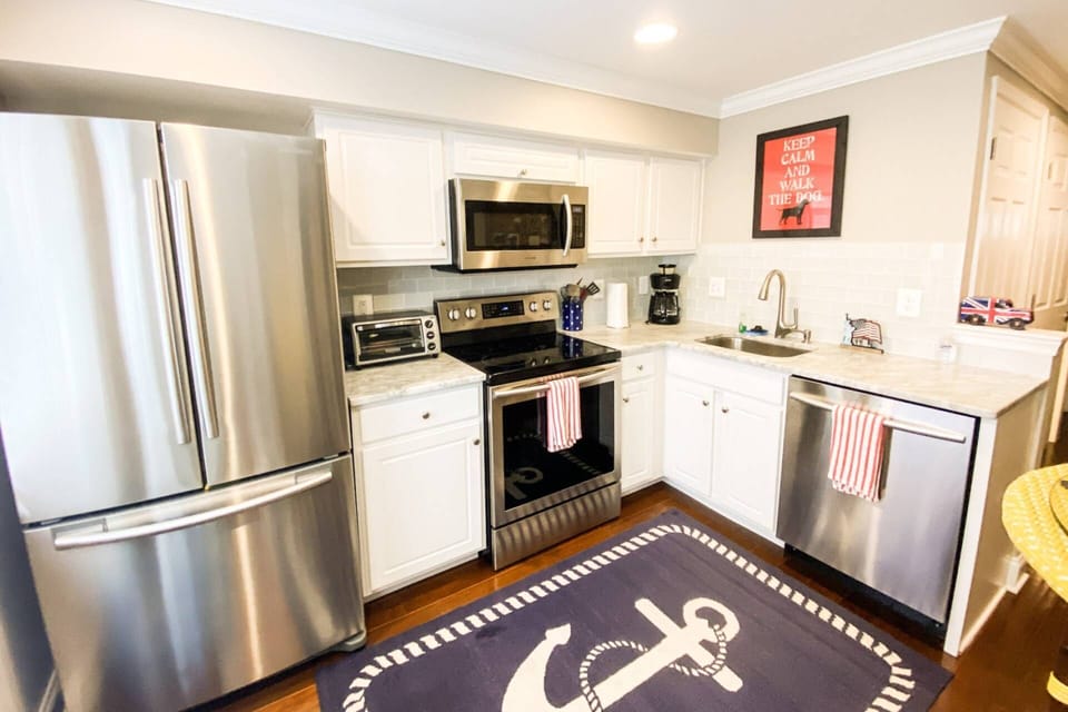 Head through the family room to the kitchen, fully stocked with cookware, plates and glasses.