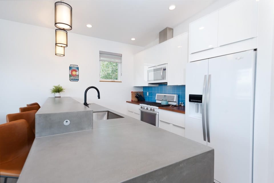 Kitchen with oven, microwave, coffee maker, refrigerator. Fully stocked with dishware and cookware.