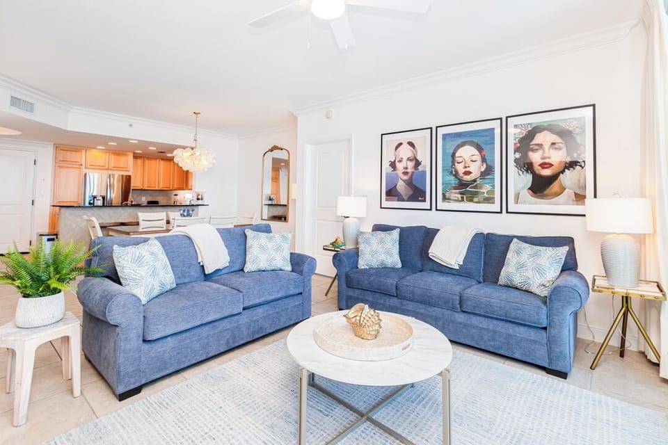 Sink into plush blue sofas in your open-concept living room, where coastal-inspired accents and warm lighting create a space perfect for unwinding after a day of adventure.