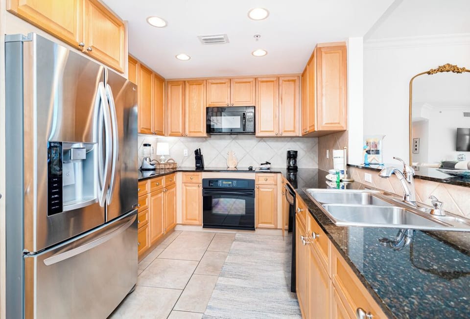 A fully equipped kitchen awaits you, featuring stainless steel appliances, ample counter space, and warm wood cabinetry. Everything you need to prepare your favorite meals during your stay.