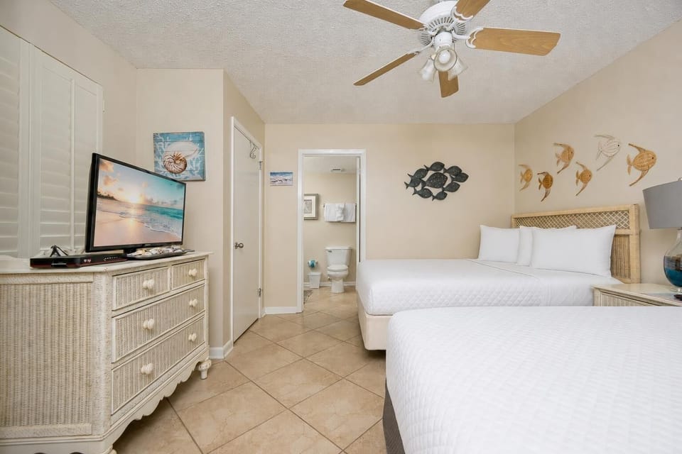 Artful fish sculptures add coastal charm as you rest on two queen beds in the guest suite
