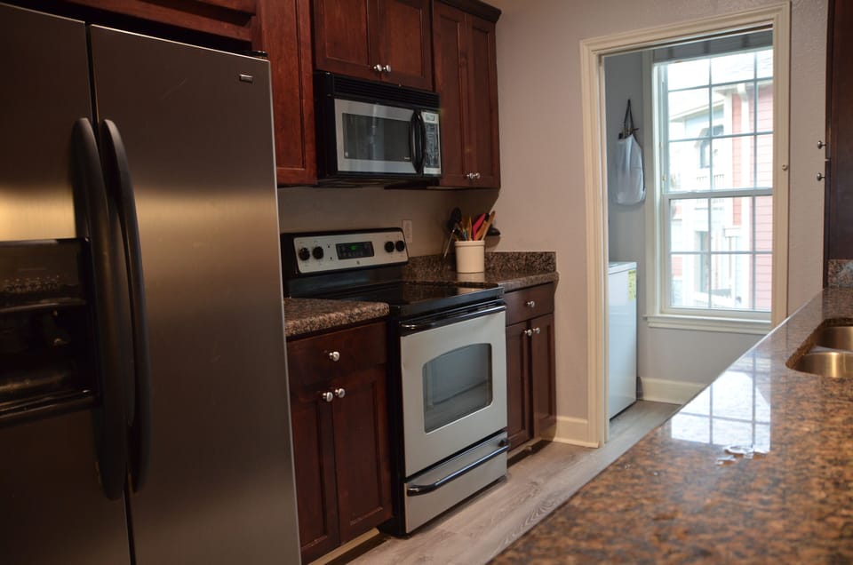 Other side of kitchen w/laundry room in background w/full size washer & dryer.