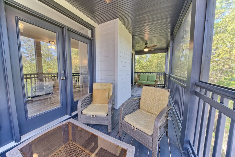 Enjoy the screened-in porch with ample seating and a ceiling fan for comfort. Direct access from interior via French doors.