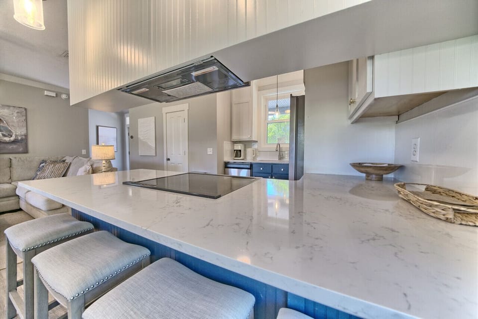 Spacious kitchen with large quartz island and seating for quick meals. Open to living room, perfect for families to socialize while cooking.