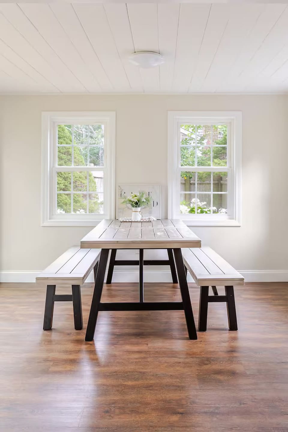 Bright dining nook with rustic table, bench seating, and garden views