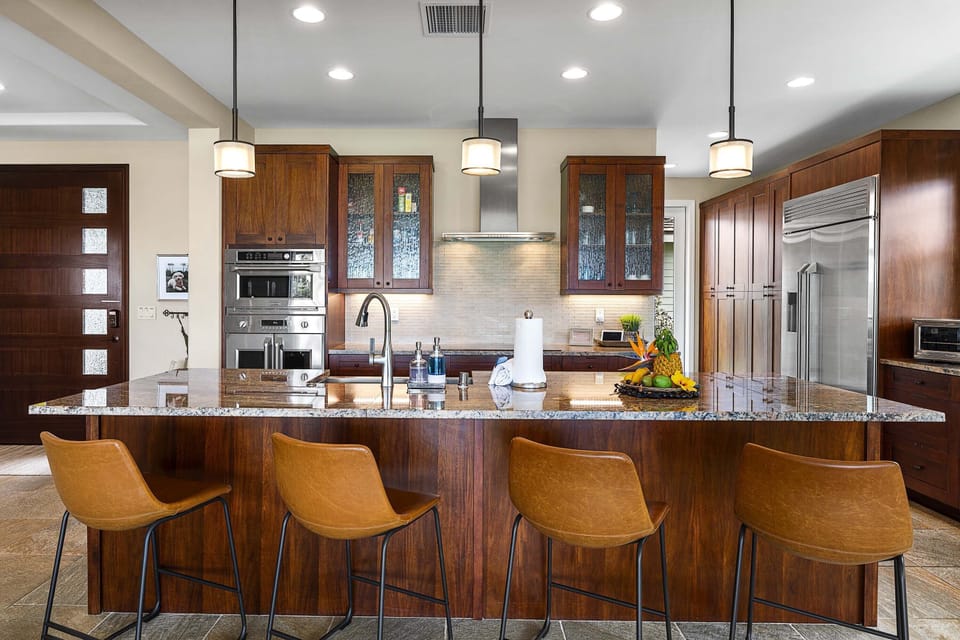 Pull up a seat at the breakfast bar in this gourmet kitchen featuring high-end finishes and custom lighting.