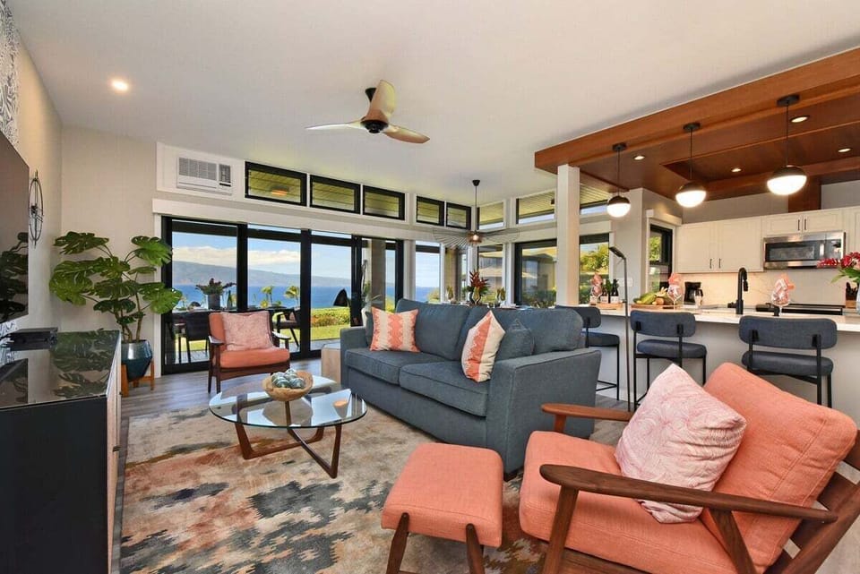 Open living area with smart TV, comfortable seating, and abundant daylight.