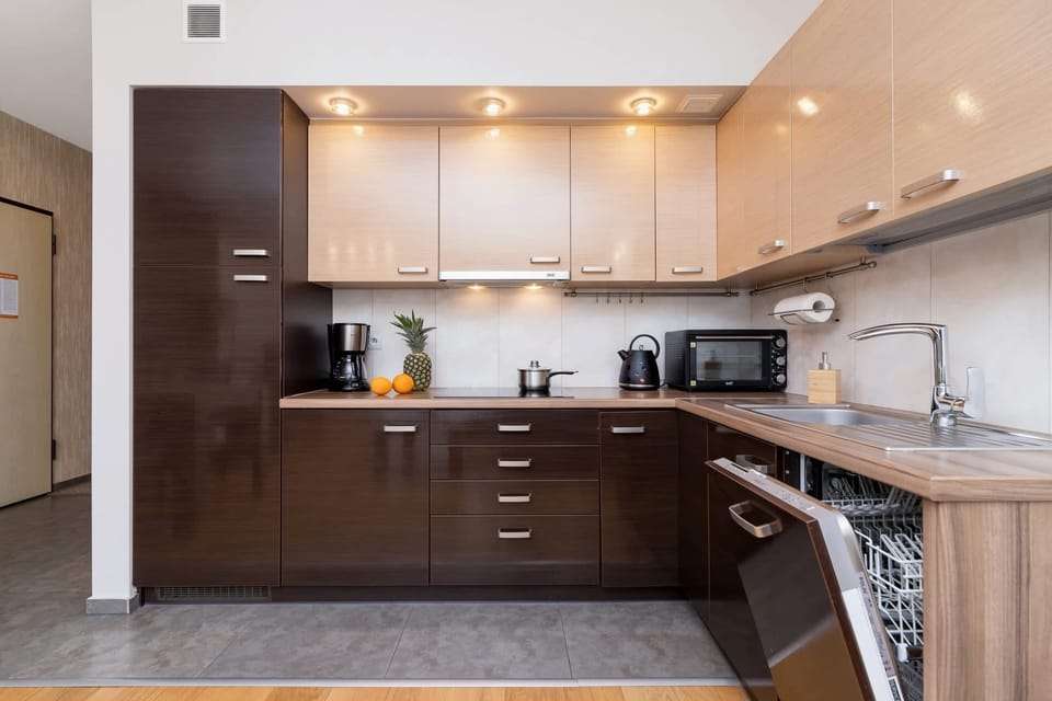 A functional kitchen with dark wooden cabinets and stainless steel appliances.