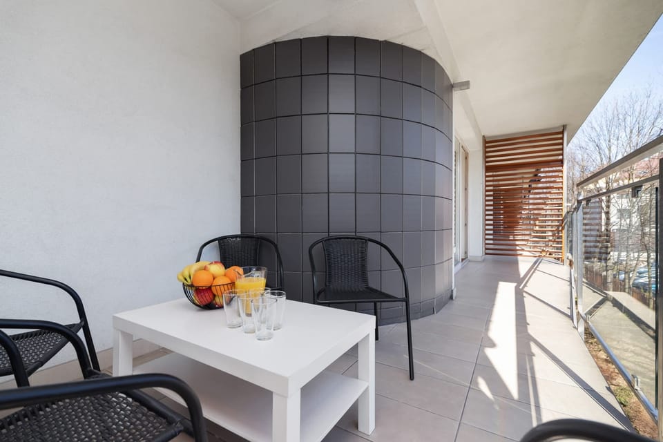 A bright area with a table and chairs on the balcony.
