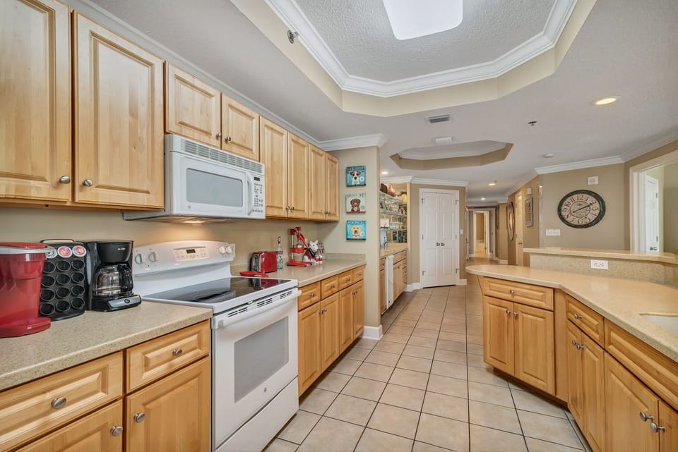 This bright kitchen is fully equipped with modern appliances to make meal prep a breeze. With ample counter space and a convenient coffee bar featuring both a single-serve and a drip coffee maker, you'll have everything you need to start your day right.