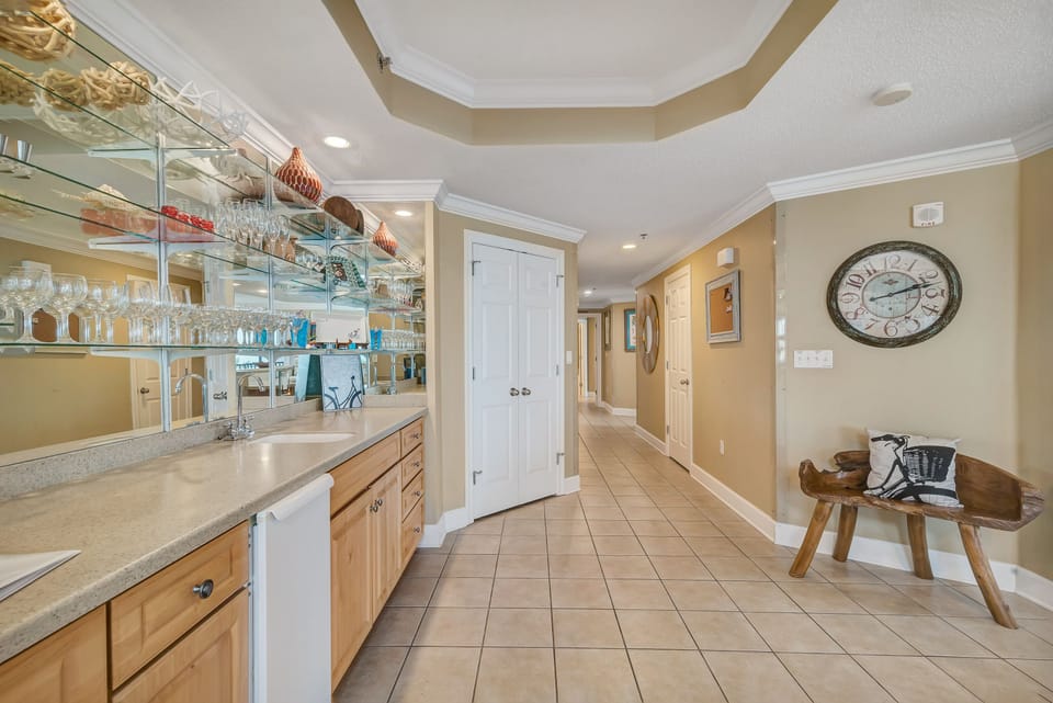 Complete with a stylish wet bar, this space is perfect for mixing up your favorite drinks. The mirrored backdrop and coastal decor create an inviting and elegant atmosphere for entertaining.