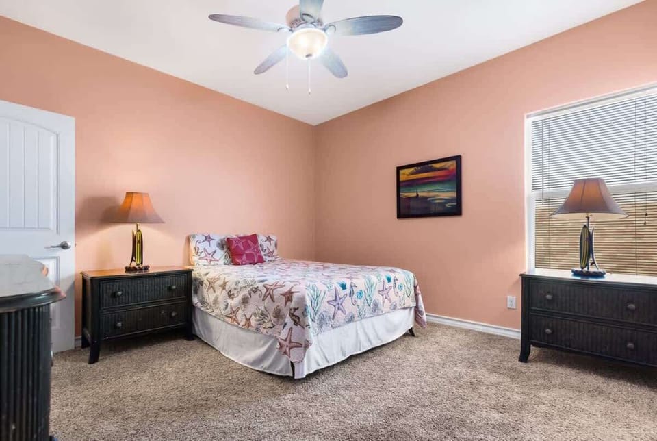Bedroom 6 — Queen Bed, Starfish Bedding, Sunset Lighthouse Painting, Dark Nightstands & Peach Walls