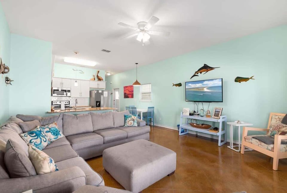 Living & Kitchen — Gray Sectional, Wall TV, Marlin Art, White Console & Kitchen Bar
