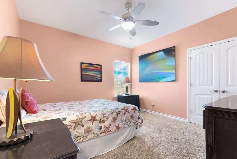 Bedroom 3 — King Bed, Starfish Bedding, Abstract Art, Sunset Painting, Surfboard Decor & Peach Walls