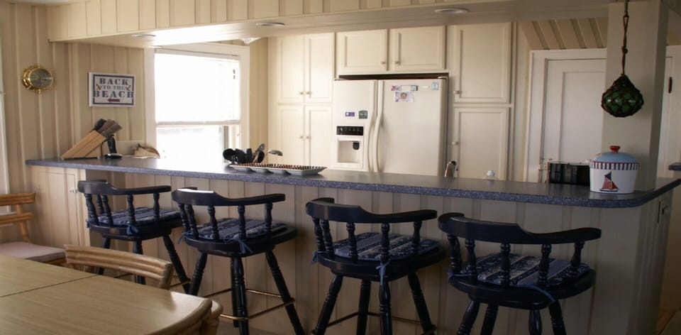 Dining table on left and bar overlooking the kitchen.