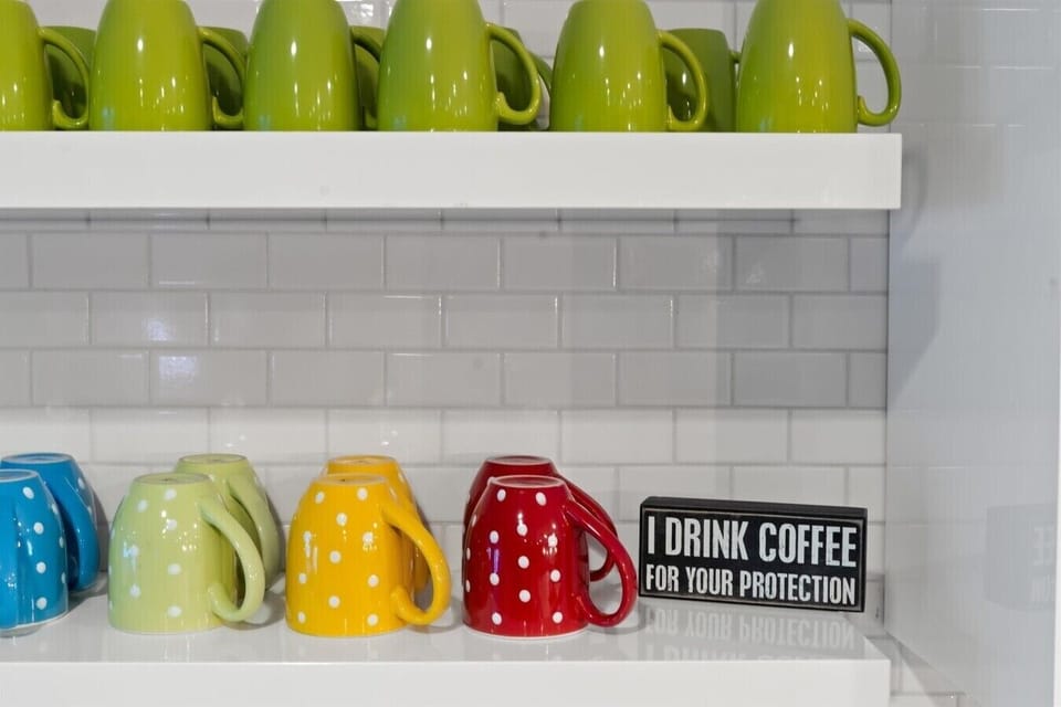 Bright, colorful mugs lined up and ready for your morning caffeine fix before heading out.