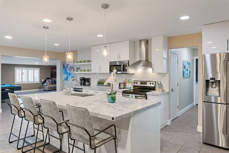 Bright, updated kitchen with stainless steel appliances, large island seating, and open flow into the living area.
