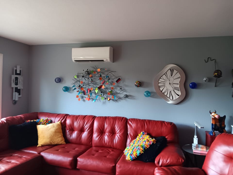 Colorful living room with spacious sofa. Leads to kitchen. 