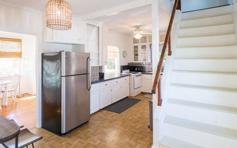 View from front entrance looking into the kitchen. Counter table with 2 stools