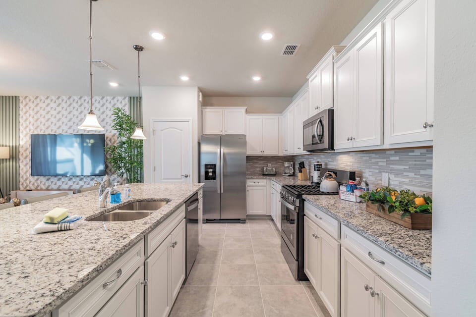 Step into this bright kitchen featuring sleek white cabinetry and elegant granite countertops. Modern appliances and a tasteful tile backsplash create a welcoming space, ideal for preparing your favorite meals.