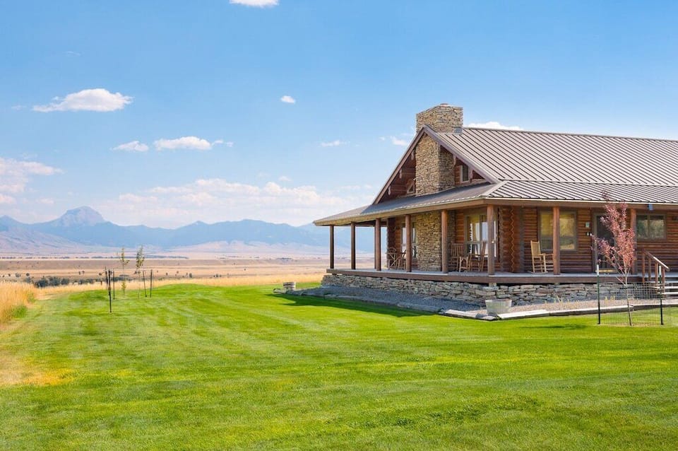 A large mowed lawn surrounds this cabin,  providing  plenty of play space.