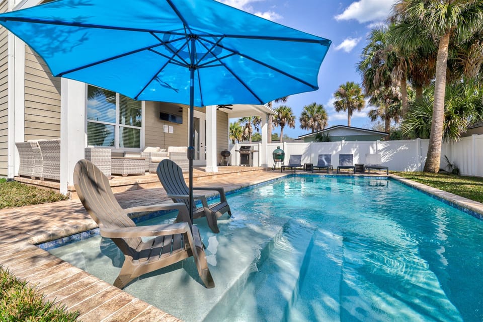 Sparkling private pool with sunny loungers and shaded umbrella seating